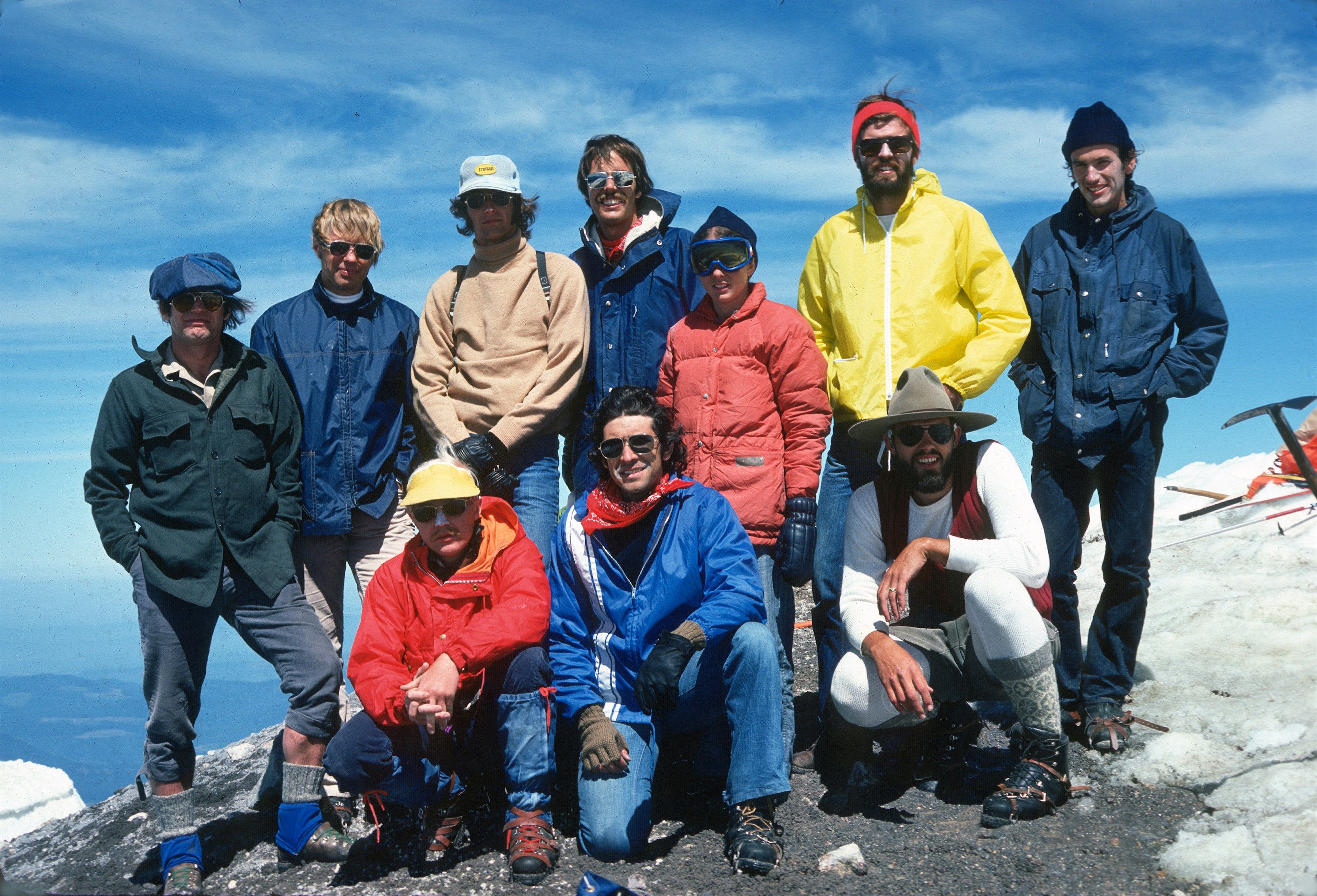 a group of people standing on top of a snow covered mountain