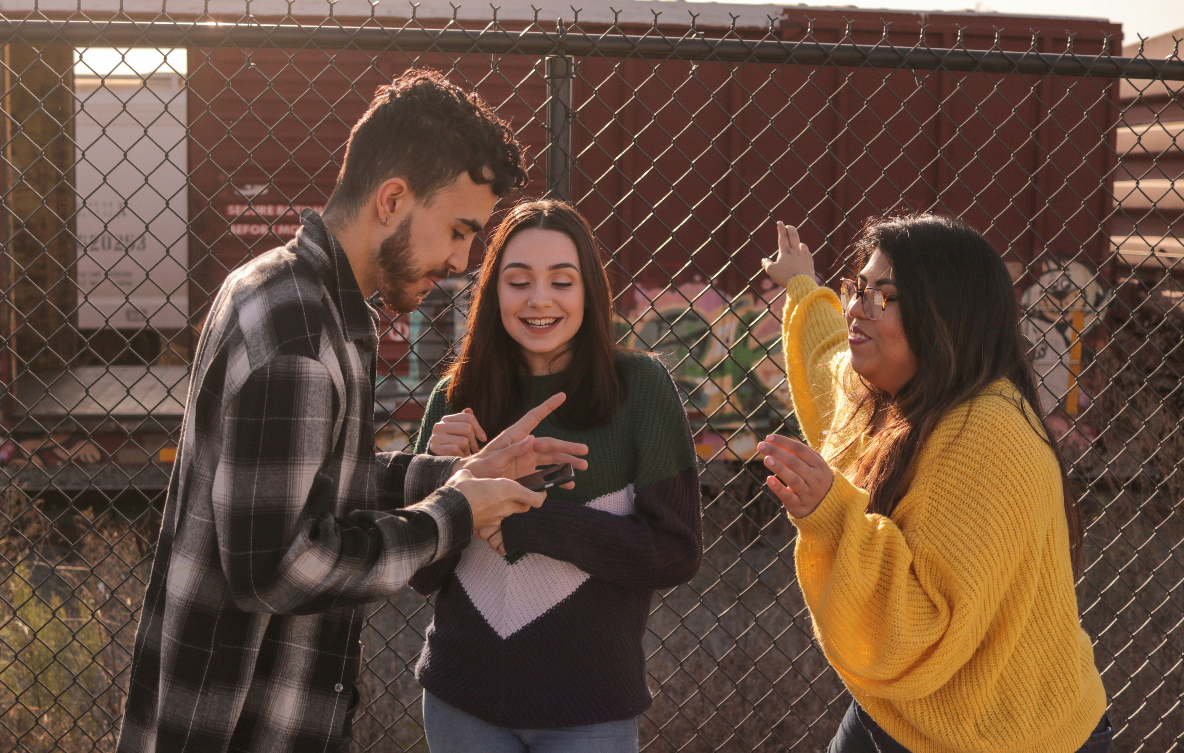 a group of people standing next to a fence