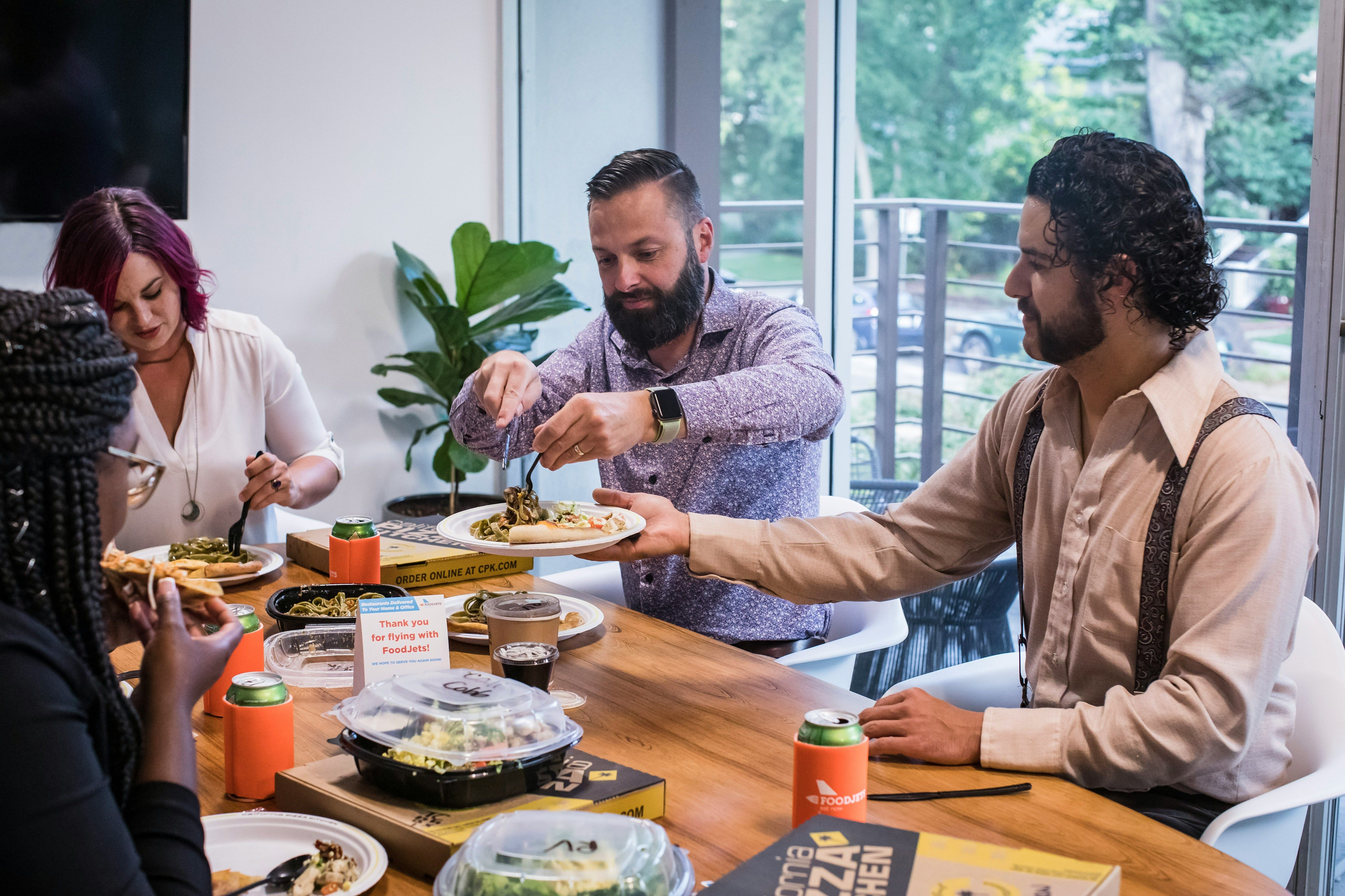 a group of people sitting around a table eating food